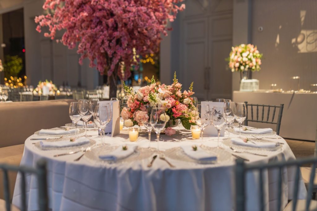 Reception table with flowers, glassware and warm lighting